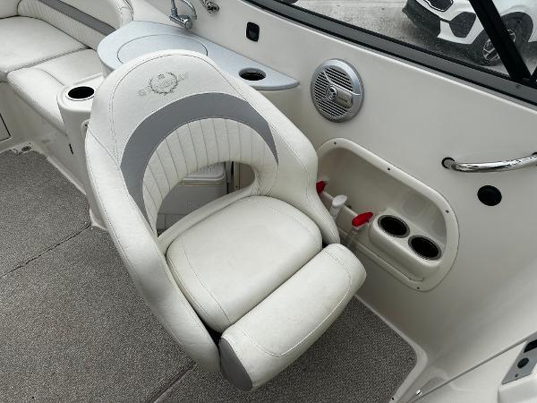 Slide: The Image of 2011 Stingray 250 LR boat interior with white captain's chair and cup holders. - 23