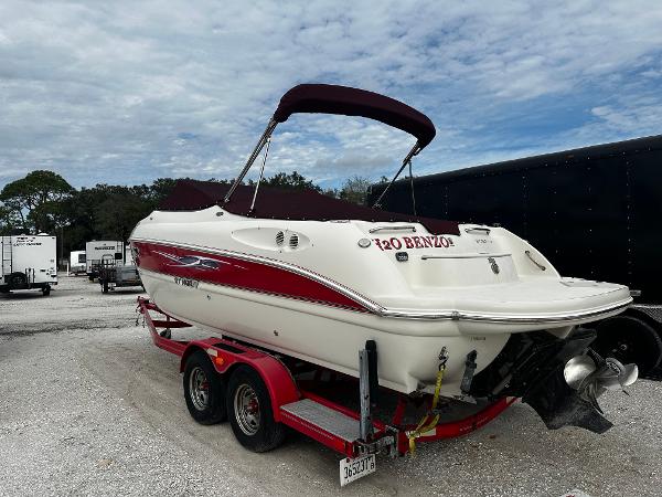 Slide: The Image of 2011 Stingray 250 LR boat on a red trailer, parked outdoors. - 5