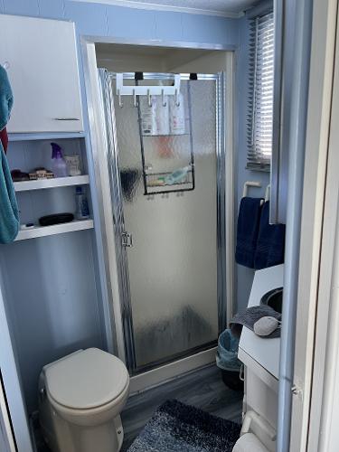 Slide: The Image of 1987 Sumerset Houseboat bathroom with shower, toilet, and storage shelves. - 13