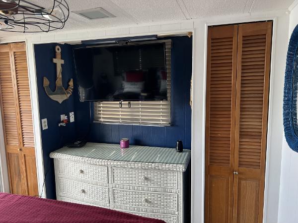 Slide: The Image of 1987 Sumerset Houseboat interior with TV, wicker dresser, and nautical decor. - 14