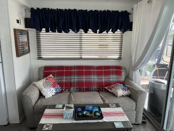 Slide: The Image of Cozy living area in a 1987 Sumerset Houseboat with a plaid-covered sofa and decorative pillows. - 15
