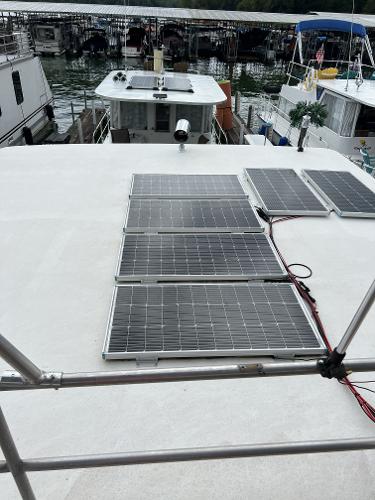 Slide: The Image of Solar panels on the roof of a 1987 Sumerset houseboat docked at a marina. - 16
