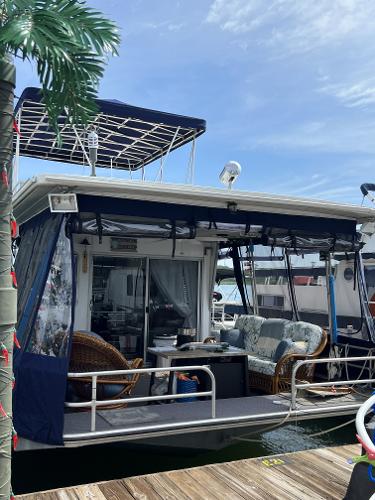 Slide: The Image of 1987 Sumerset Houseboat with outdoor seating area docked at marina. - 23
