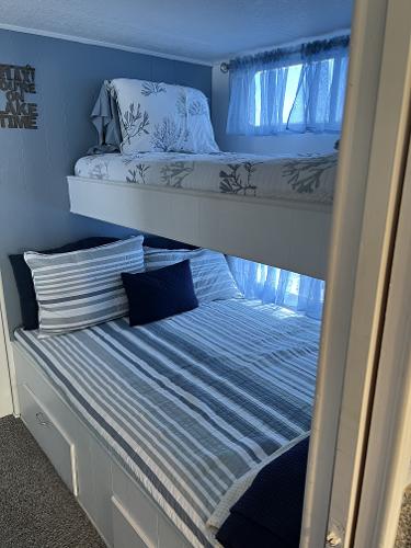 Slide: The Image of Bunk beds in a 1987 Sumerset Houseboat with nautical-themed bedding. - 24