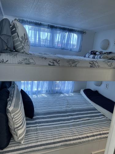 Slide: The Image of Bunk beds in a 1987 Sumerset Houseboat with striped and floral bedding. - 25