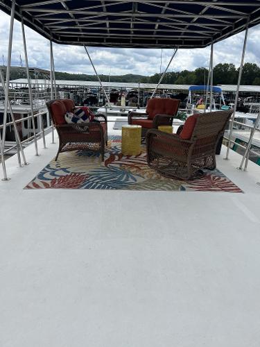 Slide: The Image of Upper deck of a 1987 Sumerset Houseboat with outdoor seating and colorful rug. - 26