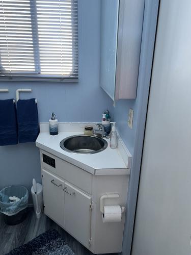 Slide: The Image of 1987 Sumerset Houseboat bathroom with sink, mirror, and blue towels. - 9