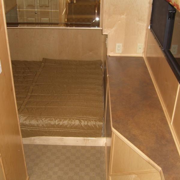 Slide: The Image of Interior of 2007 Stardust Cruisers Sundancer, featuring a cozy bed and wooden cabinetry. - 3