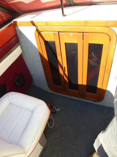 Slide: The Image of 1990 Sunbird CORSICA 188 CUDDY CABIN interior with wooden cabinet and white seat. - 11