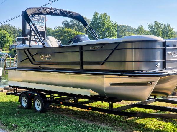 Slide: The Image of 2023 SunCatcher Fusion 322RC pontoon boat on a trailer by the lake. - 0