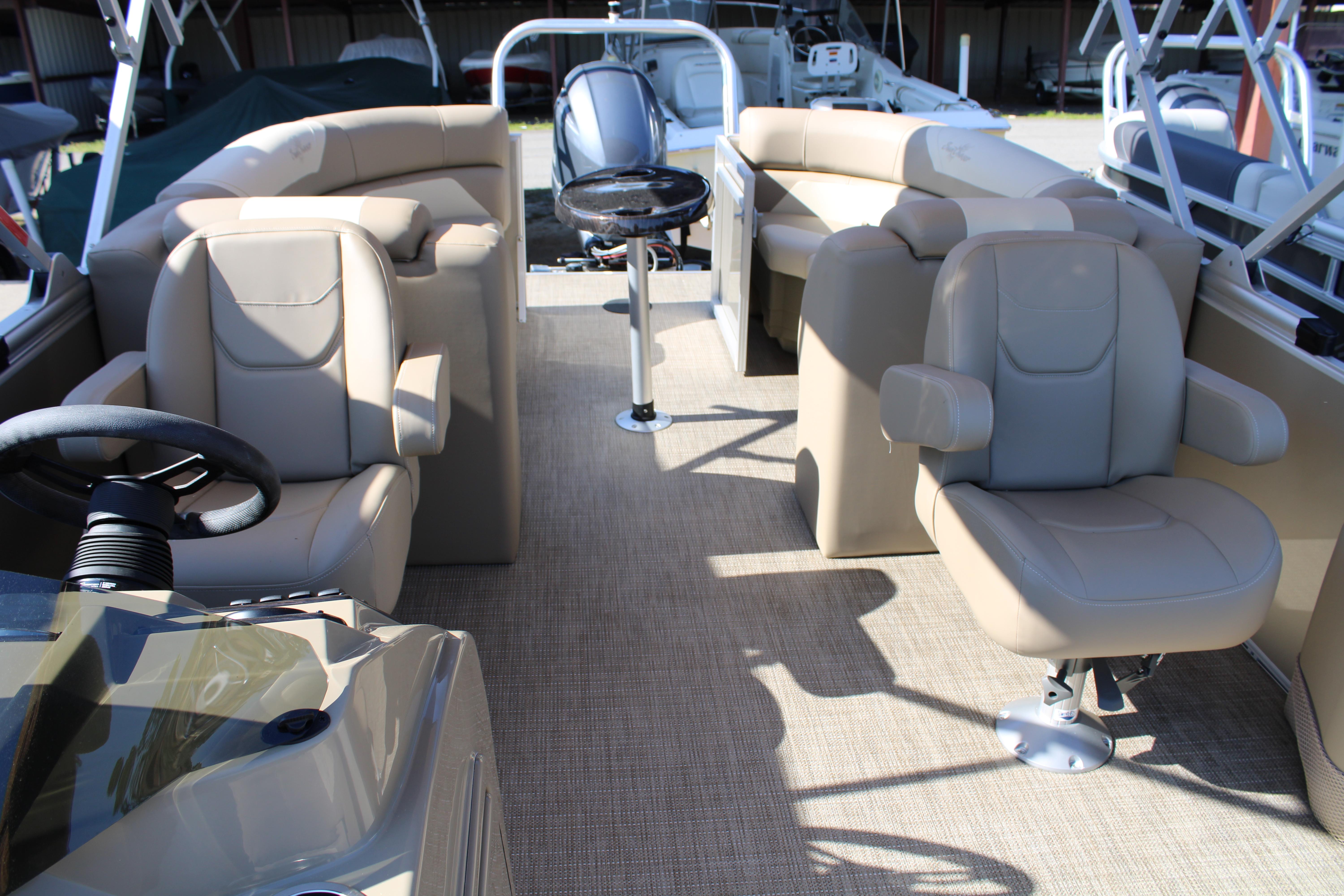Slide: The Image of 2023 SunChaser Geneva Cruise 22 LR DH pontoon boat interior with beige seating and steering console. - 6