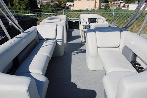 Slide: The Image of 2024 SunChaser Vista 22 LR pontoon boat interior with plush seating and modern dashboard. - 14