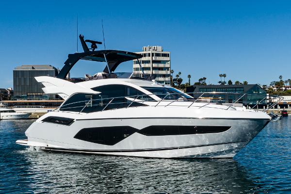 Slide: The Image of 2022 Sunseeker Manhattan 55 yacht in marina, modern design, clear blue sky. - 1