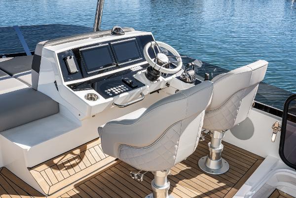 Slide: The Image of 2022 Sunseeker Manhattan 55 yacht helm station with dual seats and modern controls. - 11