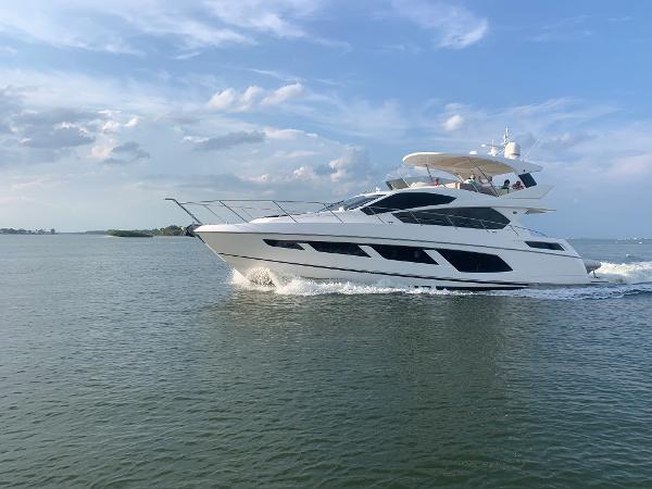 Slide: The Image of 2016 Sunseeker Manhattan 65 yacht cruising on open water under a blue sky. - 1