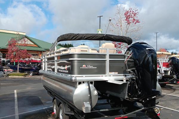 Slide: The Image of 2024 Sun Tracker Fishin' Barge 20 DLX pontoon boat in parking lot. - 2