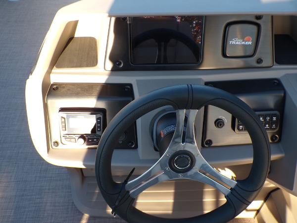 Slide: The Image of 2024 Sun Tracker FISHIN' BARGE® 22 DLX dashboard with steering wheel and control panel. - 12