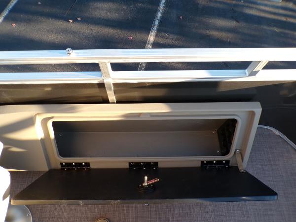 Slide: The Image of 2024 Sun Tracker FISHIN' BARGE® 22 DLX storage compartment with open lid. - 19