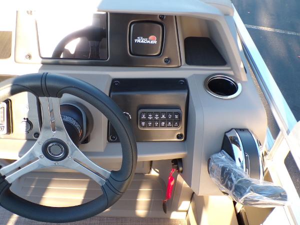 Slide: The Image of 2024 Sun Tracker FISHIN' BARGE® 22 DLX helm with steering wheel and control panel. - 21