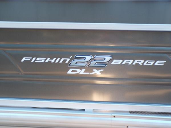 Slide: The Image of 2024 Sun Tracker FISHIN' BARGE® 22 DLX logo on boat exterior. - 6