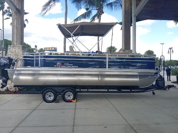 Slide: The Image of 2024 Sun Tracker Fishin' Barge 22 XP3 pontoon boat on a trailer. - 0