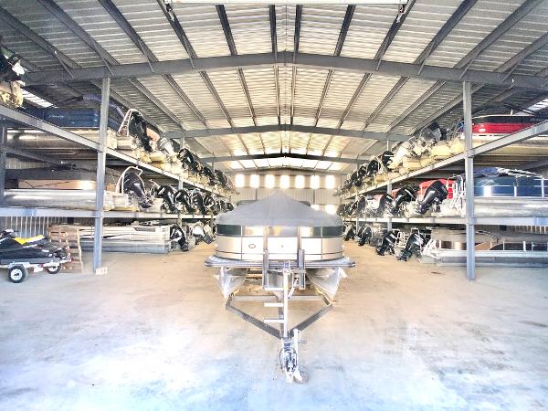 Slide: The Image of 2018 Sun Tracker Party Barge 18 DLX stored in a spacious indoor boat storage facility. - 13