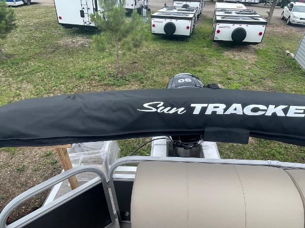 Slide: The Image of 2023 Sun Tracker Party Barge 20 DLX pontoon boat with covered motor, parked outdoors. - 7