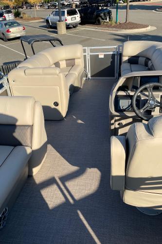 Slide: The Image of 2024 Sun Tracker Party Barge 20 DLX interior with beige seating and steering wheel. - 2