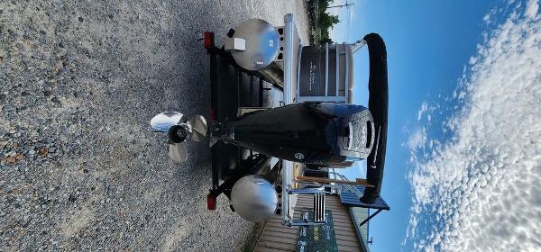 Slide: The Image of 2024 Sun Tracker PARTY BARGE® 20 DLX pontoon boat rear view with outboard motor. - 23