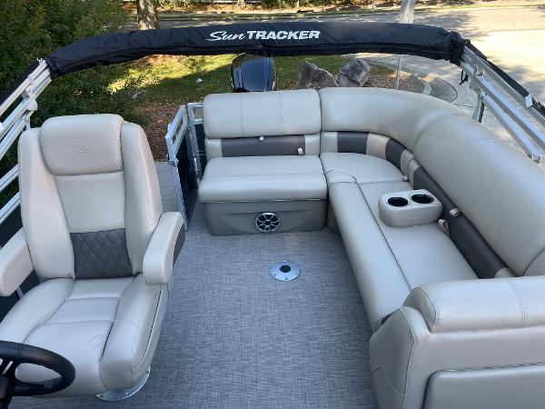 Slide: The Image of 2024 Sun Tracker Party Barge 20 DLX interior with plush seating and cup holders. - 4
