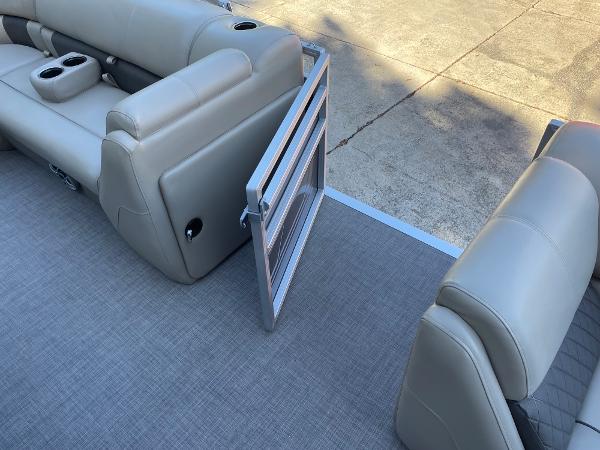 Slide: The Image of 2024 Sun Tracker Party Barge 20 DLX interior with open side gate and beige seating. - 7