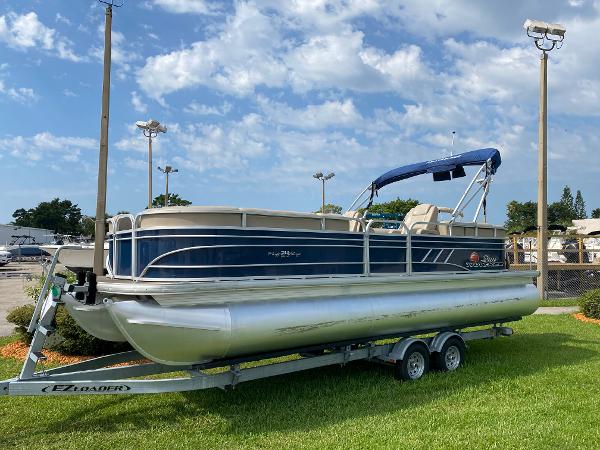 Slide: The Image of 2021 Sun Tracker Party Barge 24 DLX pontoon boat on trailer, blue and silver. - 1