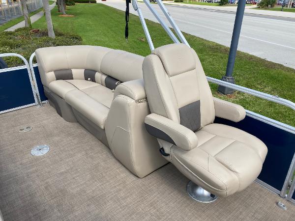 Slide: The Image of 2021 Sun Tracker Party Barge 24 DLX interior with beige seating and captain's chair. - 10