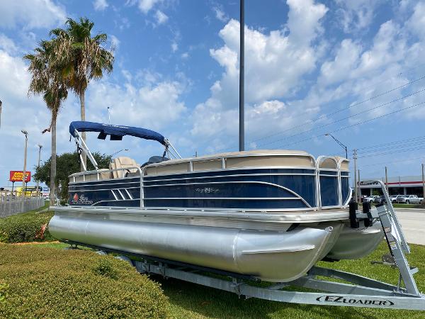 Slide: The Image of 2021 Sun Tracker Party Barge 24 DLX pontoon boat on trailer under blue sky. - 2