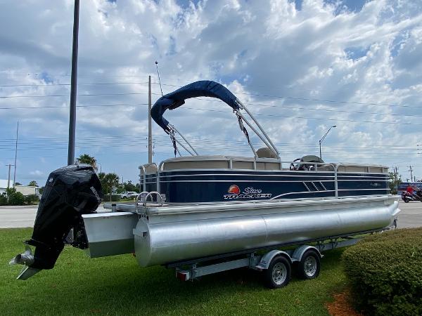 Slide: The Image of 2021 Sun Tracker Party Barge 24 DLX pontoon boat on trailer, blue sky background. - 3