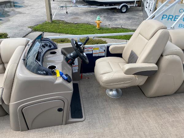 Slide: The Image of 2021 Sun Tracker Party Barge 24 DLX helm station with captain's chair and control console. - 9