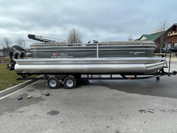Slide: The Image of 2024 Sun Tracker Party Barge 24 DLX pontoon boat on trailer in parking lot. - 0