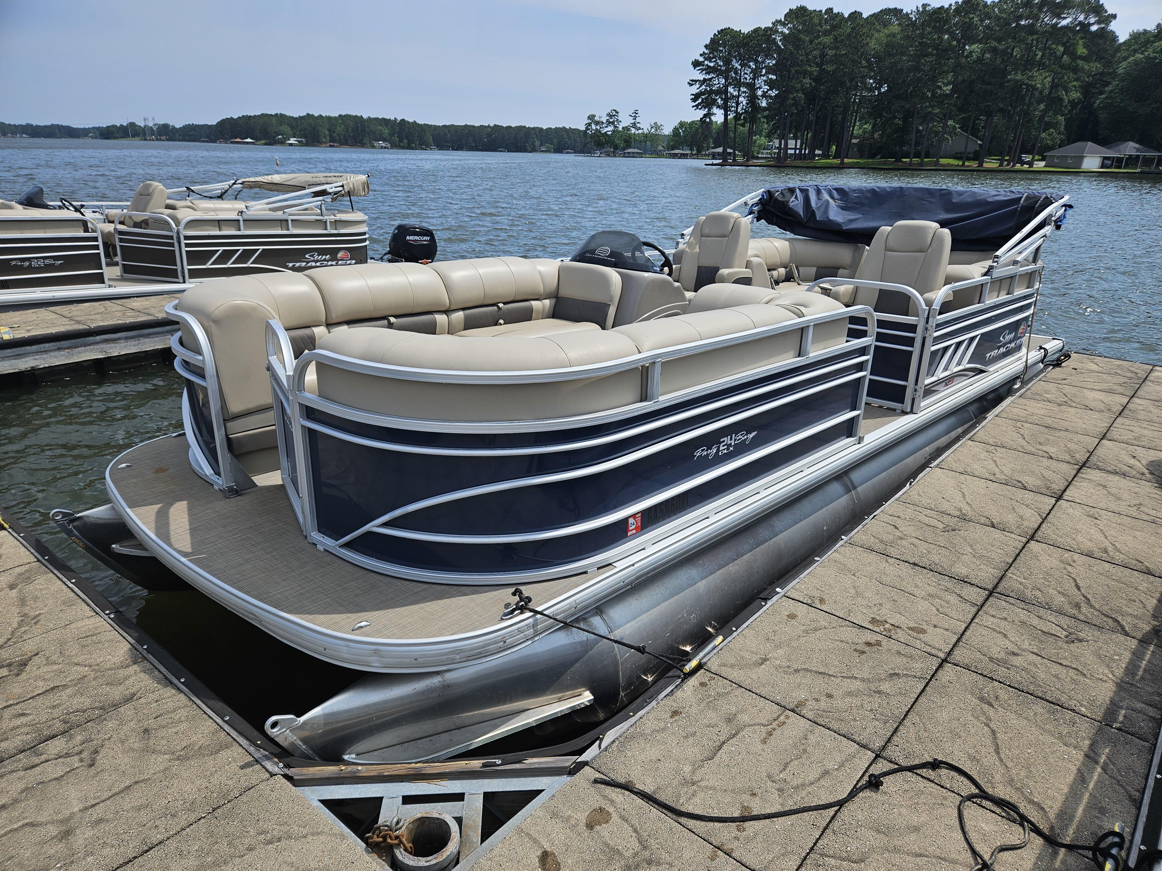 Slide: The Image of 2021 Sun Tracker Party Barge 24 XP3 pontoon boat docked on a lake. - 2