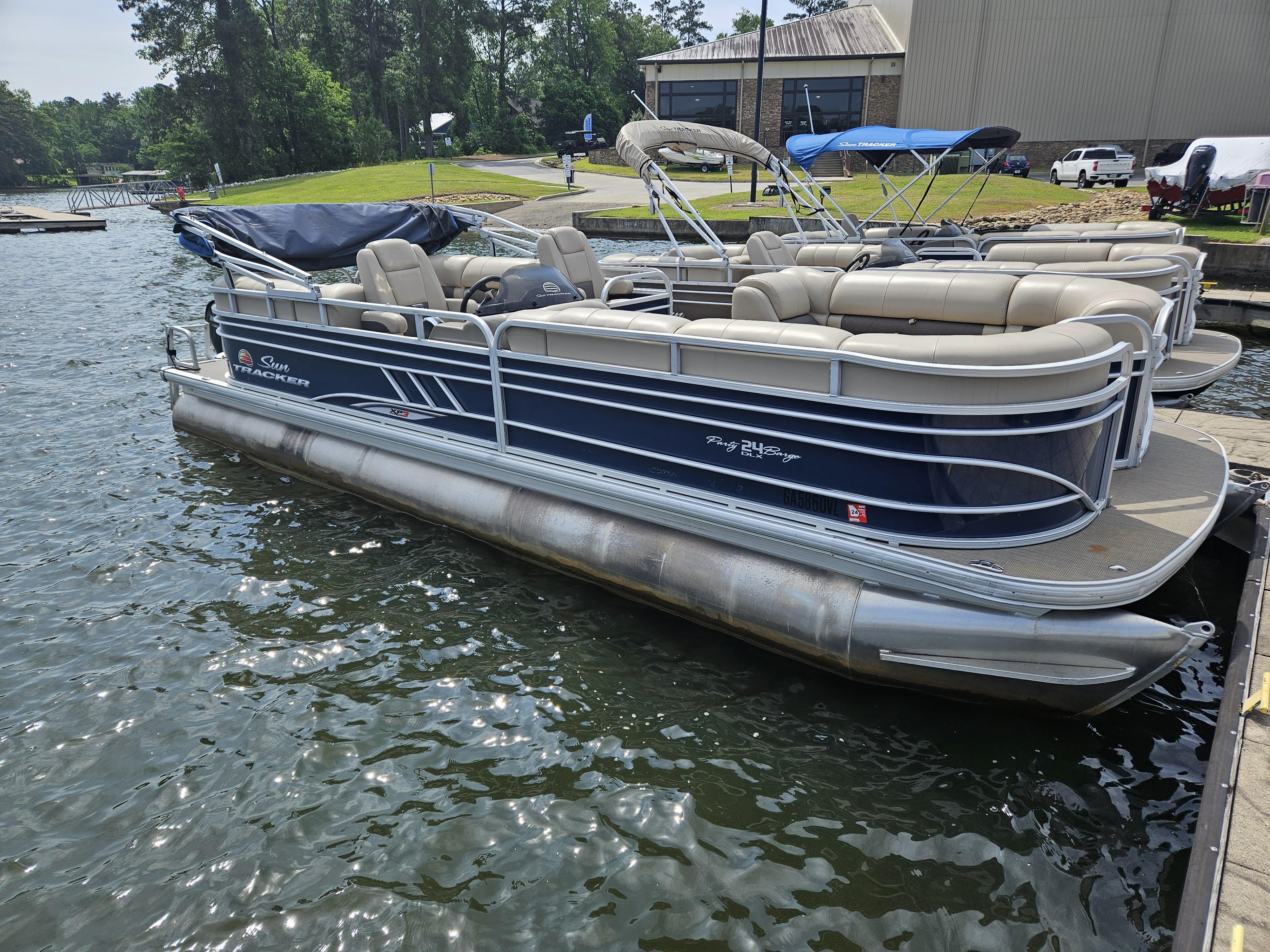 Slide: The Image of 2021 Sun Tracker Party Barge 24 XP3 pontoon boat docked on a lake. - 6