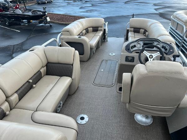 Slide: The Image of 2023 Sun Tracker SportFish 22 XP3 pontoon boat interior with beige seating and steering console. - 1