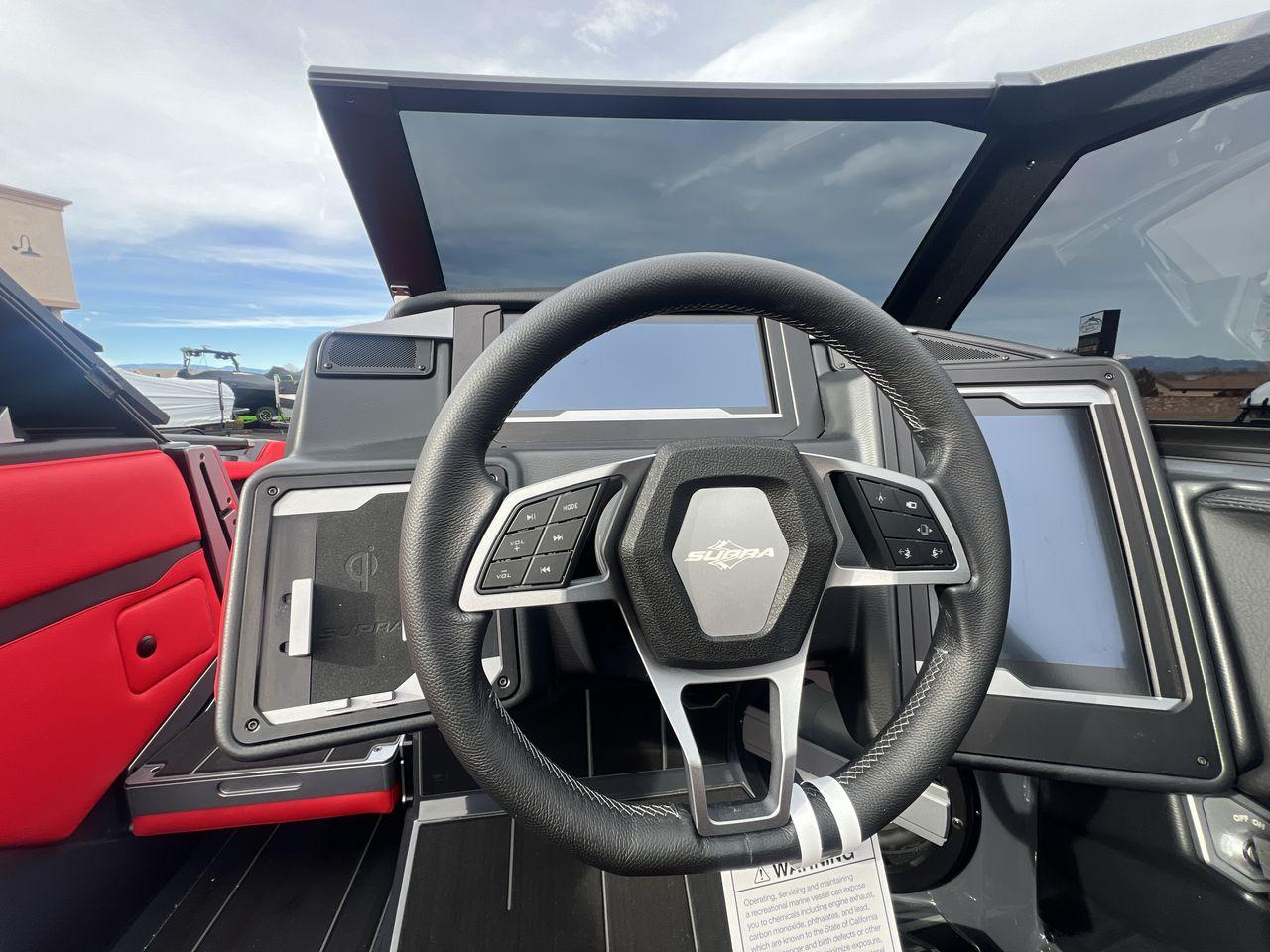 Slide: The Image of 2025 Supra SA dashboard with steering wheel and digital displays, featuring red interior accents. - 14