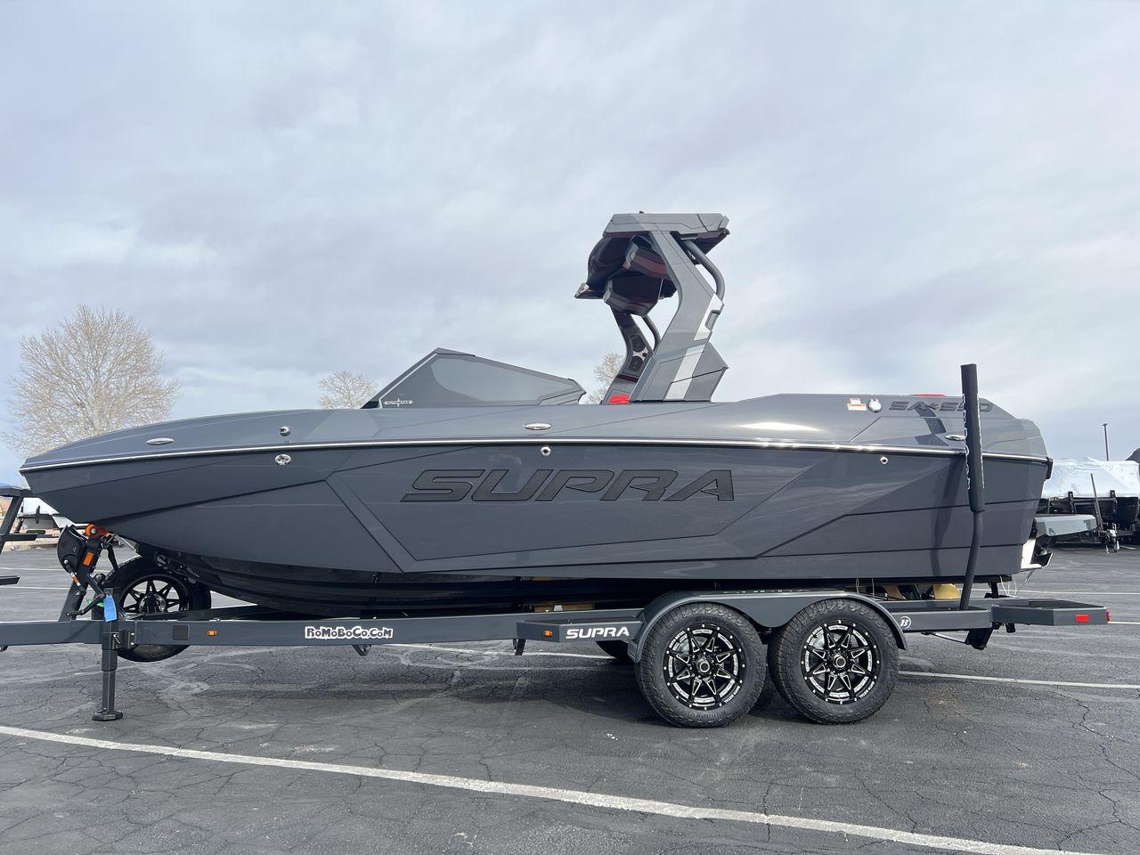 Slide: The Image of 2025 Supra SA boat on trailer, sleek design, parked outdoors. - 2