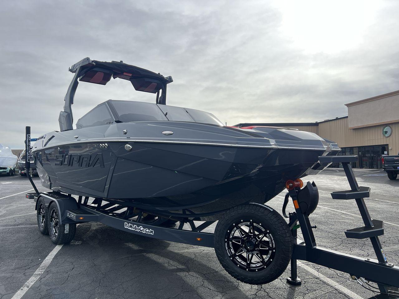 Slide: The Image of 2025 Supra SA boat on trailer in parking lot, overcast sky. - 7