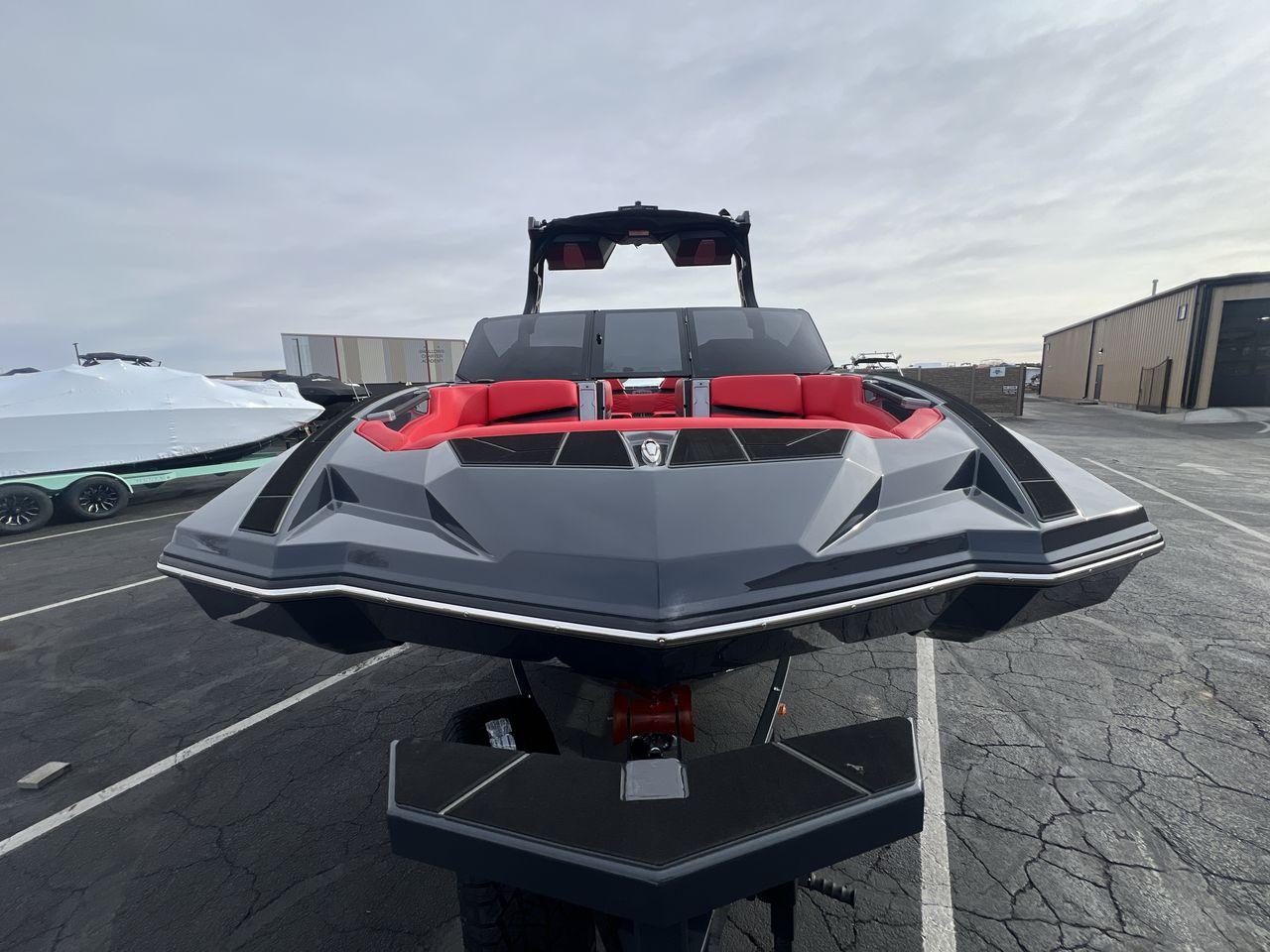 Slide: The Image of 2025 Supra SA boat with sleek design and red interior, parked outdoors. - 8