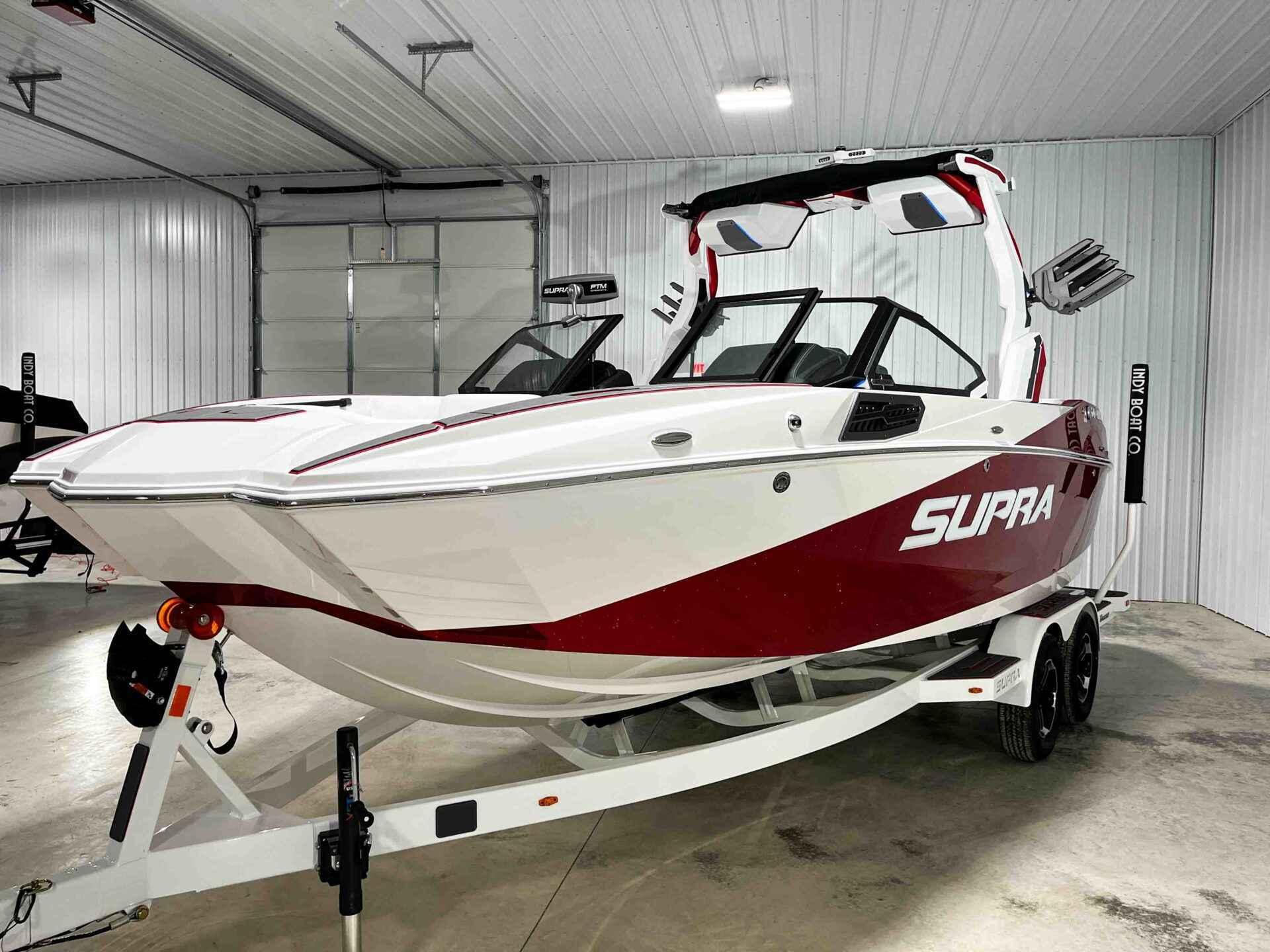 Slide: The Image of 2024 Supra SA400 boat in red and white, displayed in an indoor showroom. - 12
