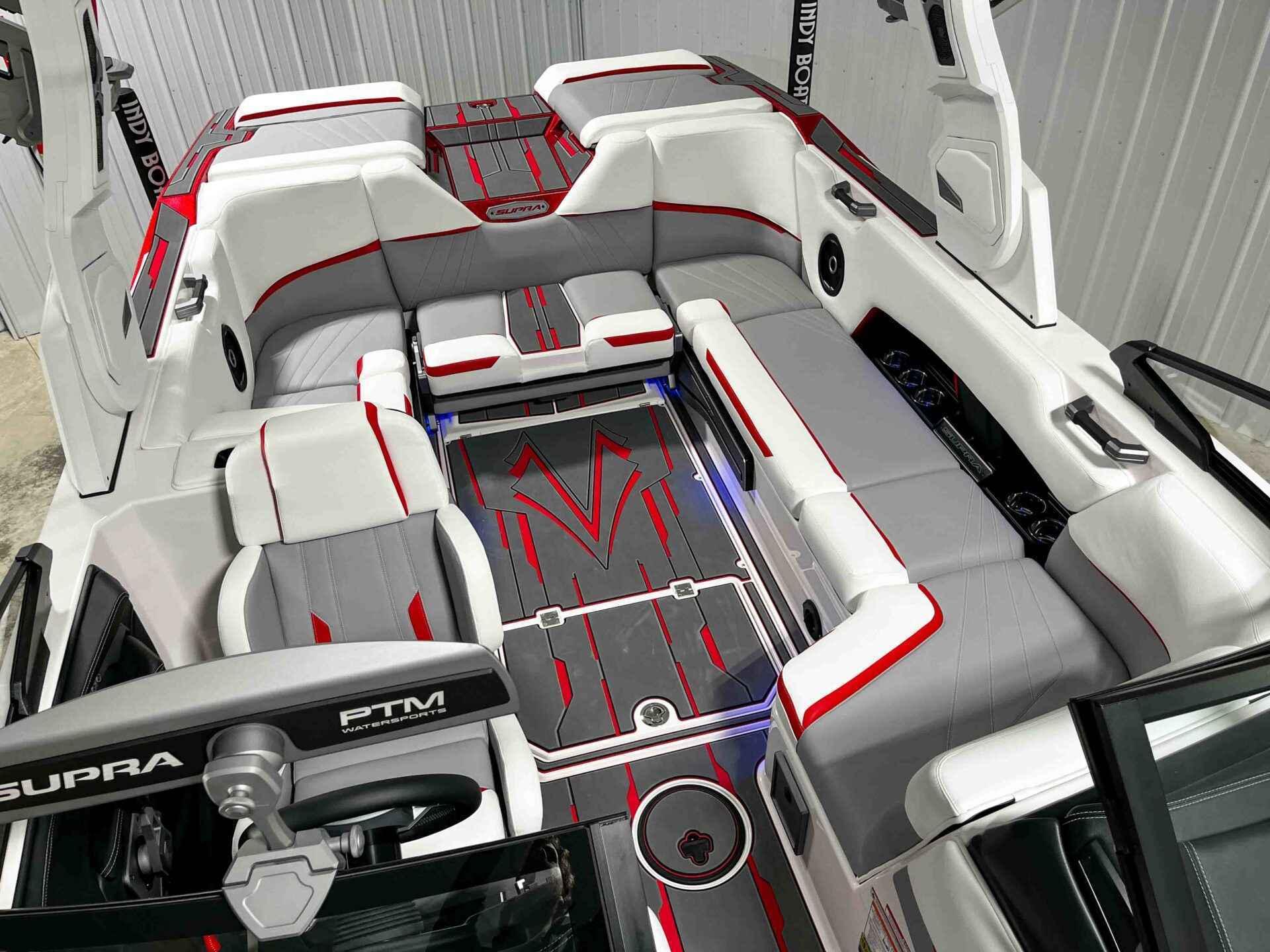 Slide: The Image of 2024 Supra SA400 boat interior with red and gray accents, spacious seating, and modern design. - 25