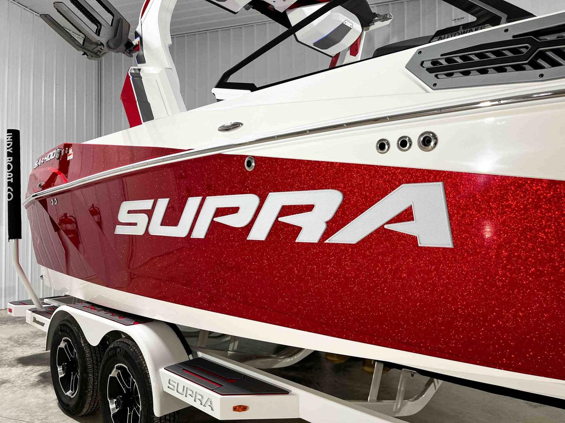 Slide: The Image of 2024 Supra SA400 boat in red and white, side view, on trailer. - 5