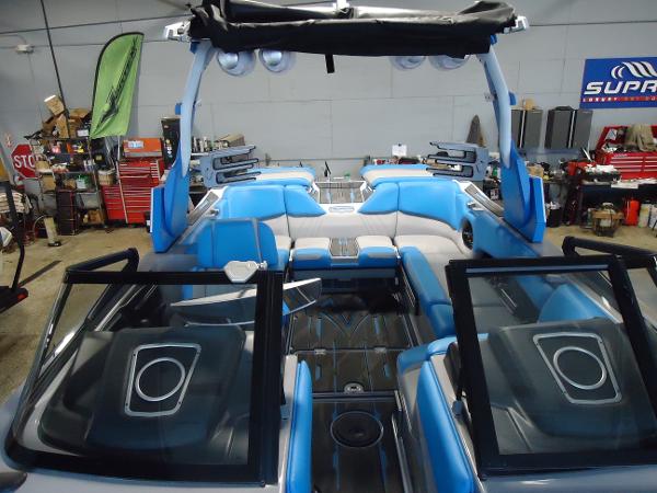 Slide: The Image of 2022 Supra SA 450 boat interior with blue and gray seating in a workshop. - 10