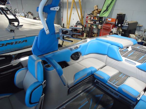 Slide: The Image of 2022 Supra SA 450 boat interior with blue and white seating in a workshop. - 9