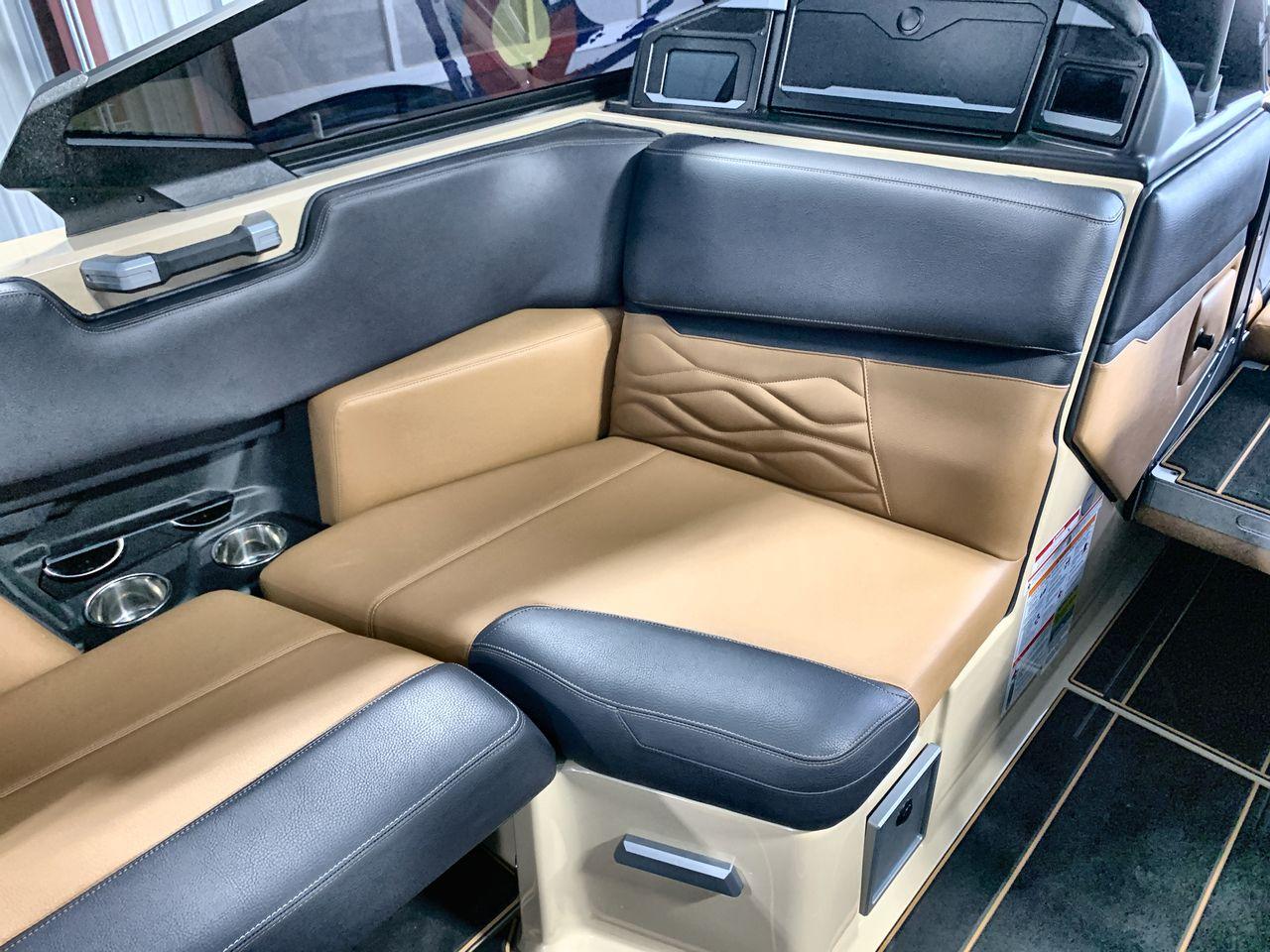 Slide: The Image of 2025 Supra SE boat interior with tan and black leather seating, cup holders, and modern design. - 16